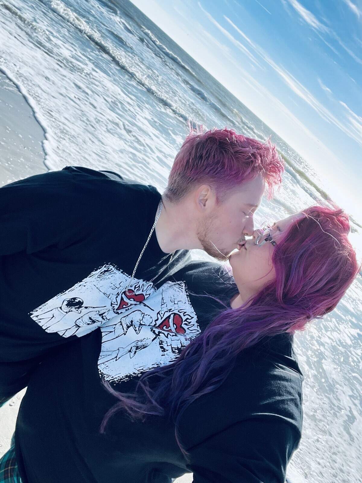 Samuel Ranz and Melissa Ranz kiss on the beach in Wilmington, North Carolina on their honeymoon road trip.