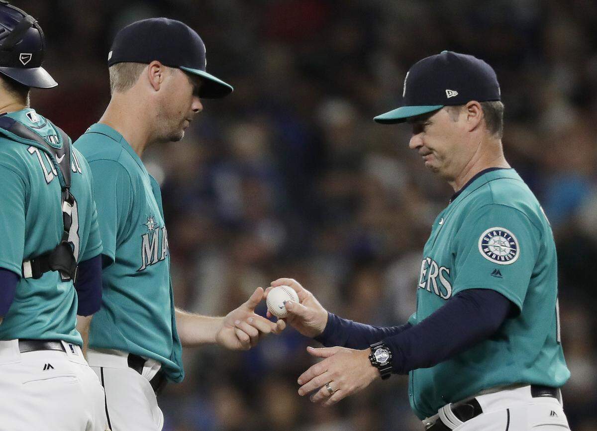 Seattle Mariners starting pitcher Wade LeBlanc, left, hands the ball to manager Scott Servais, right, as LeBlanc is pulled in the fifth inning of a baseball game against the Los Angeles Dodgers, Friday, Aug. 17, 2018, in Seattle. (AP Photo/Ted S. Warren)