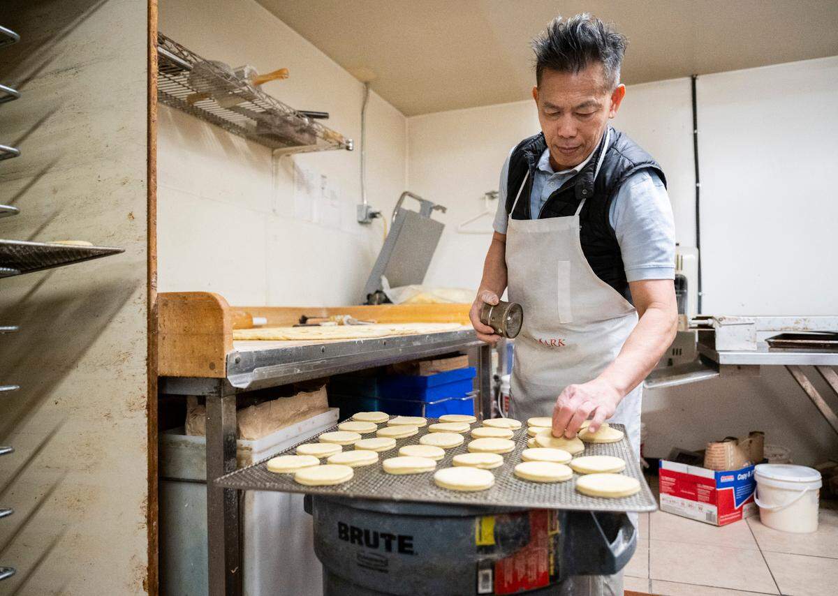 Yam batches, shapes and forms hundreds of doughnuts, largely by hand. This tray of rounds, headed to the proofer, will be filled with jelly or custard after frying.