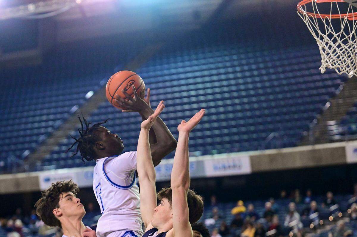 Curtis guard Zoom Diallo (center) attempts a shot as Gonzaga Prep guard Henry Sandberg (left) and guard Jackson Floyd (right) defend during the first quarter of a Class 4A quarterfinal state tournament game on Thursday, March 3, 2022, at the Tacoma Dome, in Tacoma, Wash.