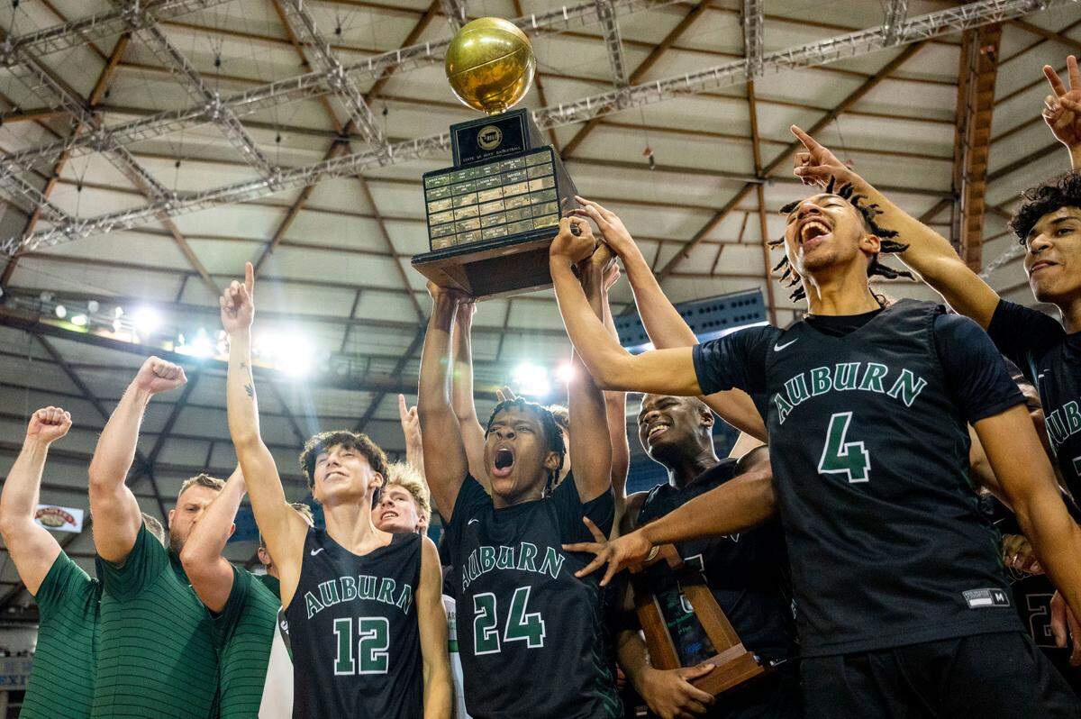 Senior guard Dae’Kwon Watson (24) lifts the state championship trophy after Auburn beat Rainier Beach, 58-48, in the Class 3A championship game on Saturday, March 5, 2022, at the Tacoma Dome, in Tacoma, Wash.