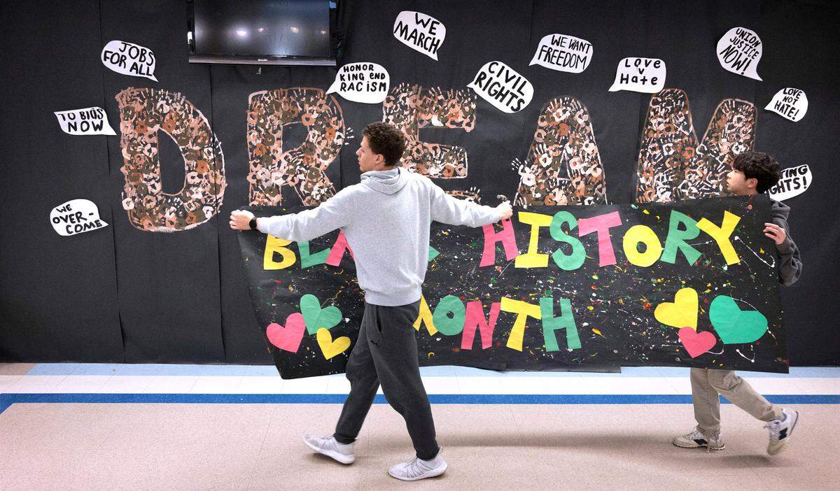 Gig Harbor senior Sam Haddon (left) and junior Ezra Hwang prepare to hang a Black History Month banner during the weekly meeting of the Black Student Union at Gig Harbor High School in Gig Harbor, Washington, on Tuesday, Feb. 7, 2023.