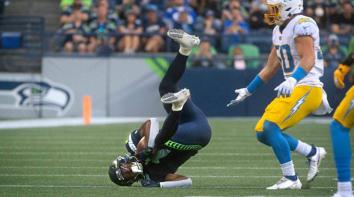 Seattle wide receiver Dee Eskridge pulls down a pass in front of Los Angeles linebacker Cole Christiansen during Saturday night’s NFL preseason football game against the Los Angeles Chargers at Lumen Field in Seattle, Washington, on Aug. 28, 2021.