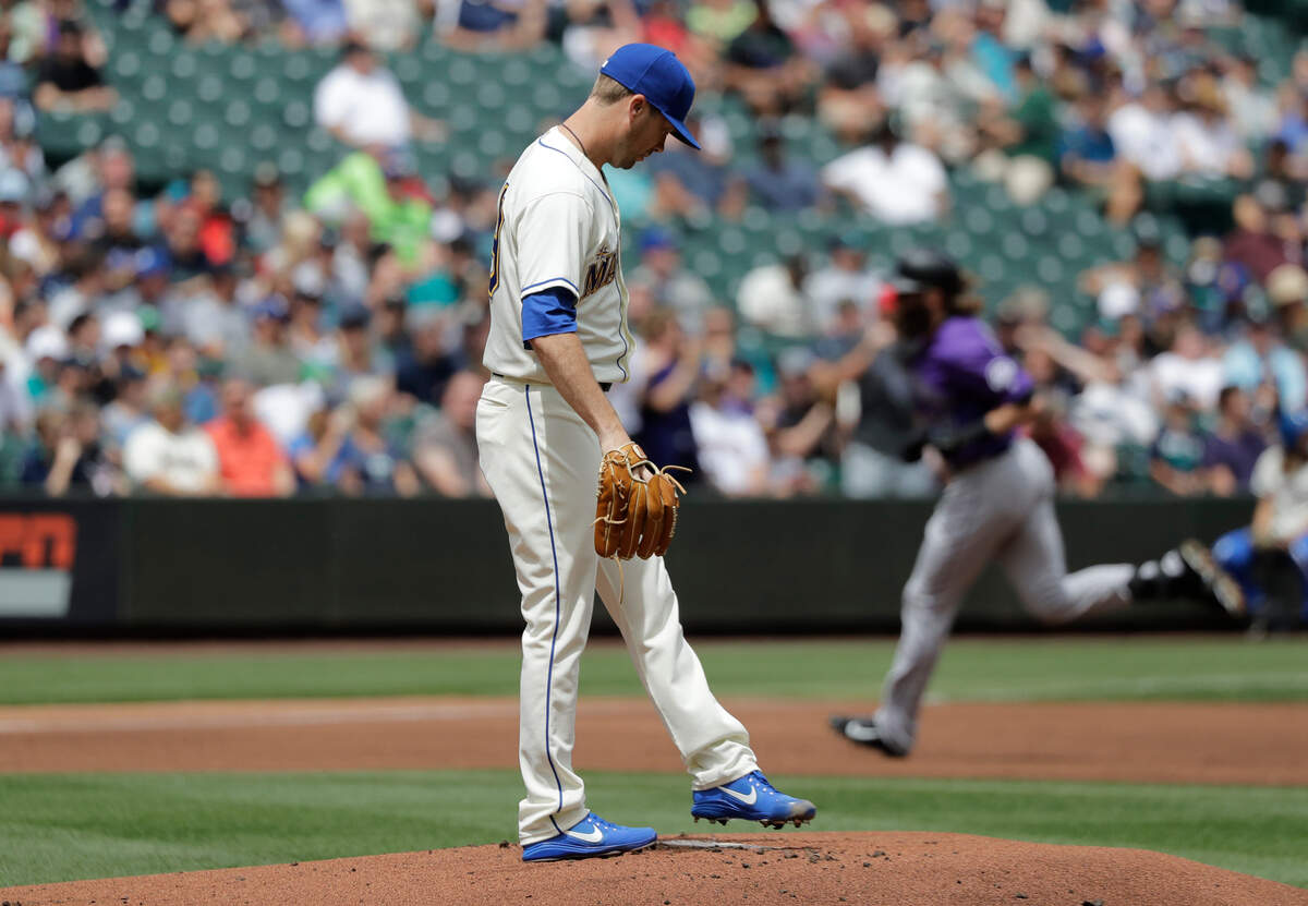 Seattle Mariners starting pitcher Wade LeBlanc, foreground, stands on the mound as Colorado Rockies' Charlie Blackmon, back right, rounds the bases after Blackmon hit a solo home run during the first inning of a baseball game, Sunday, July 8, 2018, in Seattle. (AP Photo/Ted S. Warren)