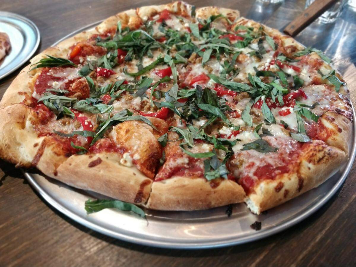 A large Spanish Steps pizza with fresh basil from Zeeks Pizza in Tacoma.