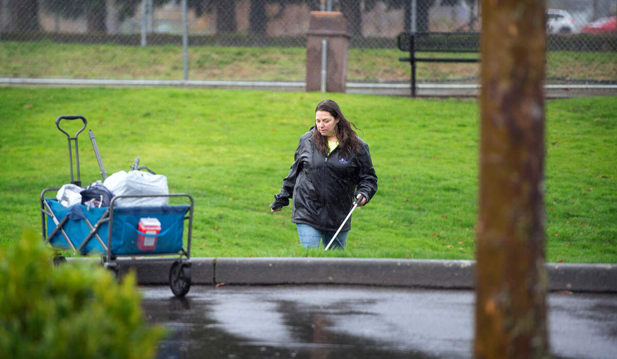 Katlin Lawless, founder of the unofficial “Sumner Cleaning Crew” that now boasts more than 100 members, picks up trash on her walk around Daffodil Valley Athletic Complex in Sumner, Washington, on Saturday, Dec. 11, 2021.
