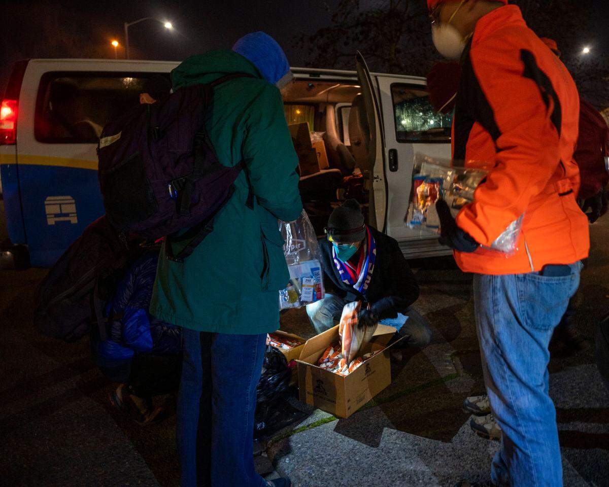 Point-in-Time Count volunteers stock up on supplies to give out to homeless people as they do their annual census of people living unhoused in Pierce County on Thursday, Jan. 27, 2022.
