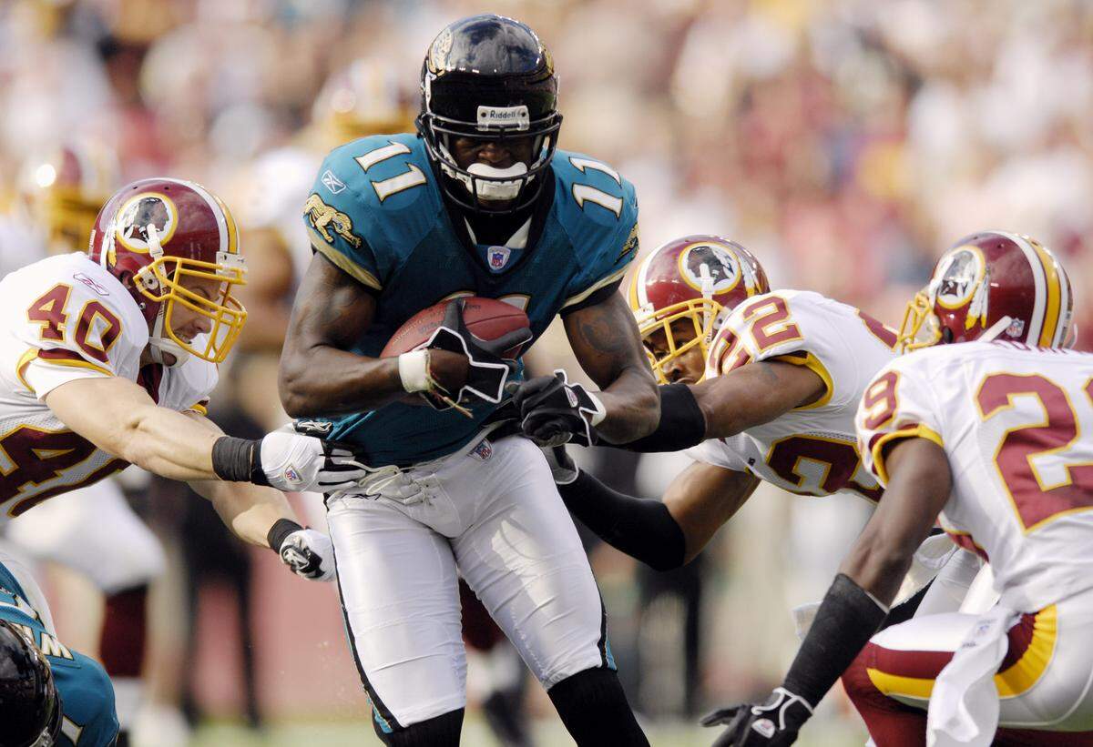 Jacksonville Jaguars wide receiver Reggie Williams, center, breaks tackles en route to a 33-yard pass reception for a touchdown against Washington Redskins defenders, from left, Adam Archuleta, Carlos Rogers and Mike Rumph, during the first quarter of an NFL football game, Sunday, Oct. 1, 2006, in Landover, Md. (AP Photo/Nick Wass)