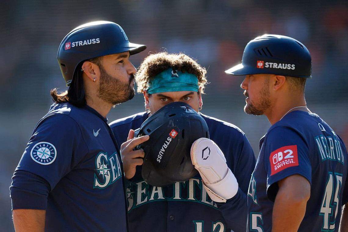 DETROIT, MICHIGAN - OCTOBER 08: Eugenio SuÃ(degrees)rez #28, Josh Naylor #12, and third base coach Kristopher NegrÃ³n #45 of the Seattle Mariners speak during a pitching change during the fourth inning of game four of the American League Division Series against the Detroit Tigers at Comerica Park on October 08, 2025 in Detroit, Michigan. (Photo by Duane Burleson/Getty Images)