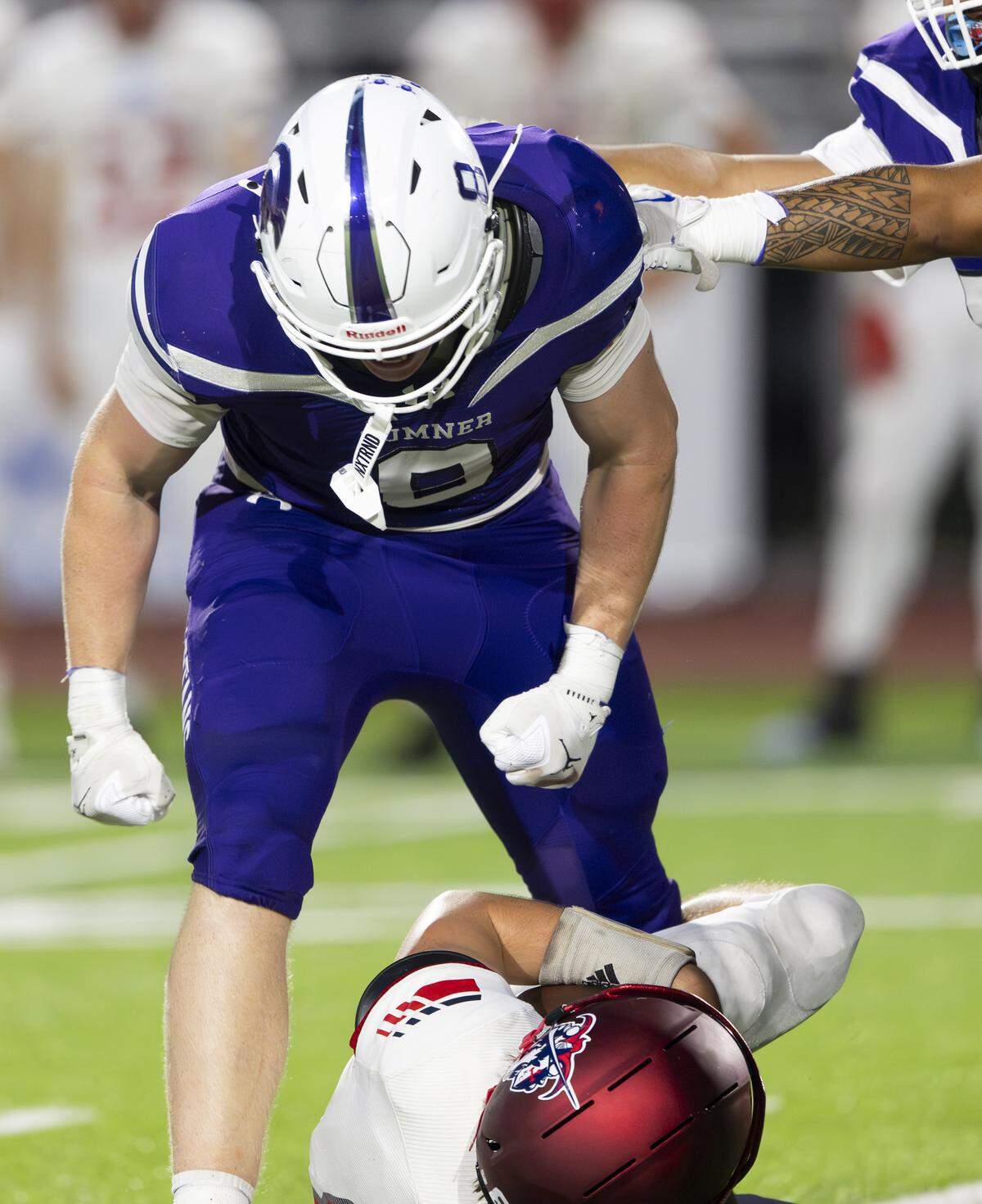 Sumner defensive end Gray Longoria (8) stands over Kennedy Catholic quarterback Dante Saladino (8) after a sack during the first half of the game at Sunset Chev Stadium on Friday, Sept. 12, 2025, in Sumner, Wash.