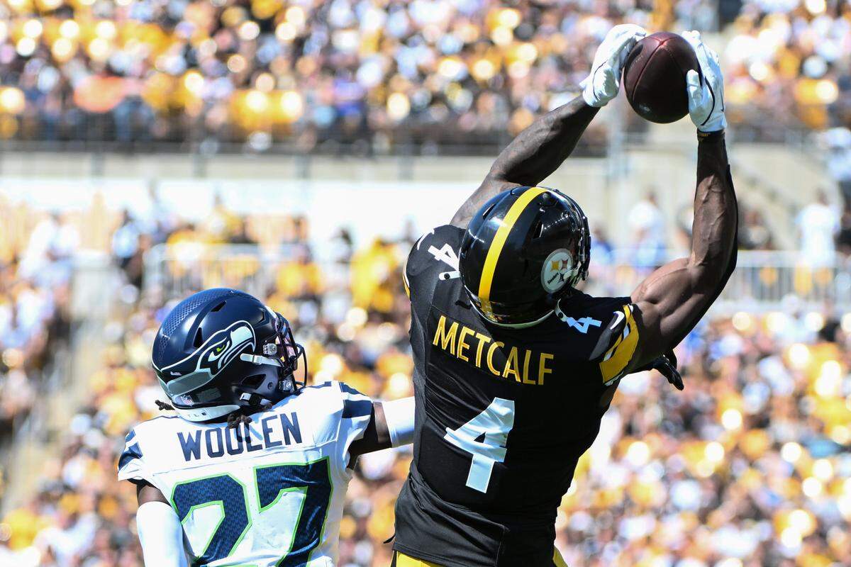Sep 14, 2025; Pittsburgh, Pennsylvania, USA; Pittsburgh Steelers wide receiver DK Metcalf (4) catches a pass over Seattle Seahawks cornerback Riq Woolen (27) during the second quarter at Acrisure Stadium. Mandatory Credit: Barry Reeger-Imagn Images