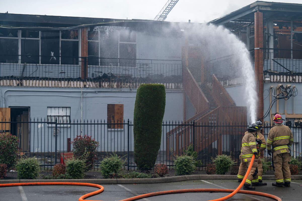 Firefighters from the West Pierce Fire Department hose down hot spots on the backside of a building that caught fire on Wednesday morning on the 9600 block of Gravelly Lake Drive in Lakewood. No injuries were reported, but the fire is still under investigation.