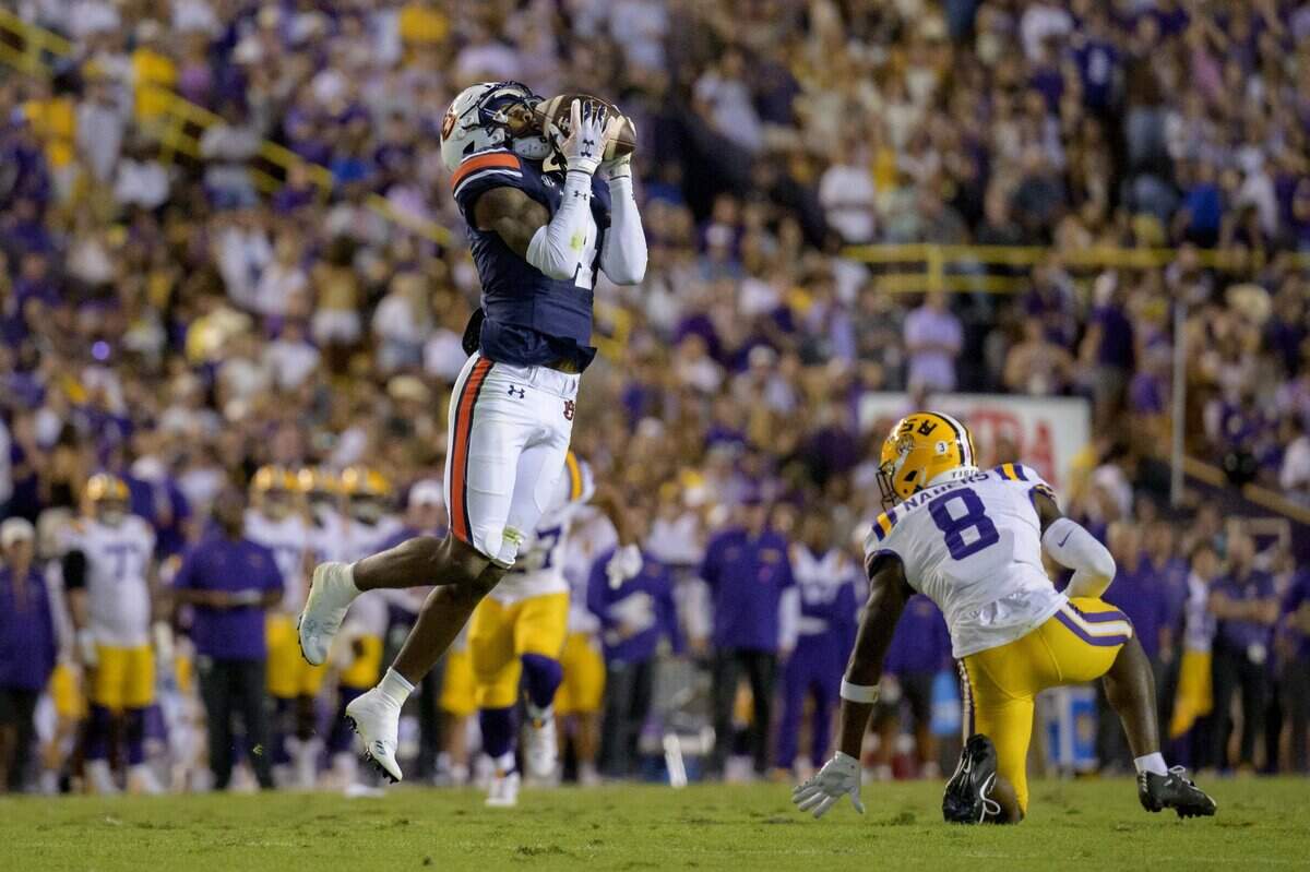 Oct 14, 2023; Baton Rouge, Louisiana, USA; Auburn Tigers cornerback D.J. James (4) makes a interception against LSU Tigers wide receiver Malik Nabers (8) during the second quarter at Tiger Stadium. Mandatory Credit: Matthew Hinton-USA TODAY Sports