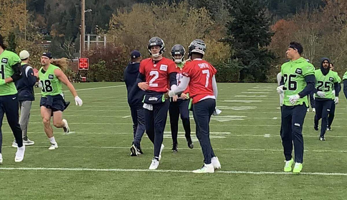 Geno Smith (7) practices and slaps hands with his backup Drew Lock (2) on Wednesday, Nov. 22, 2023, three days after Smith bruised his triceps in the Seahawks’ game at the Los Angeles Rams.