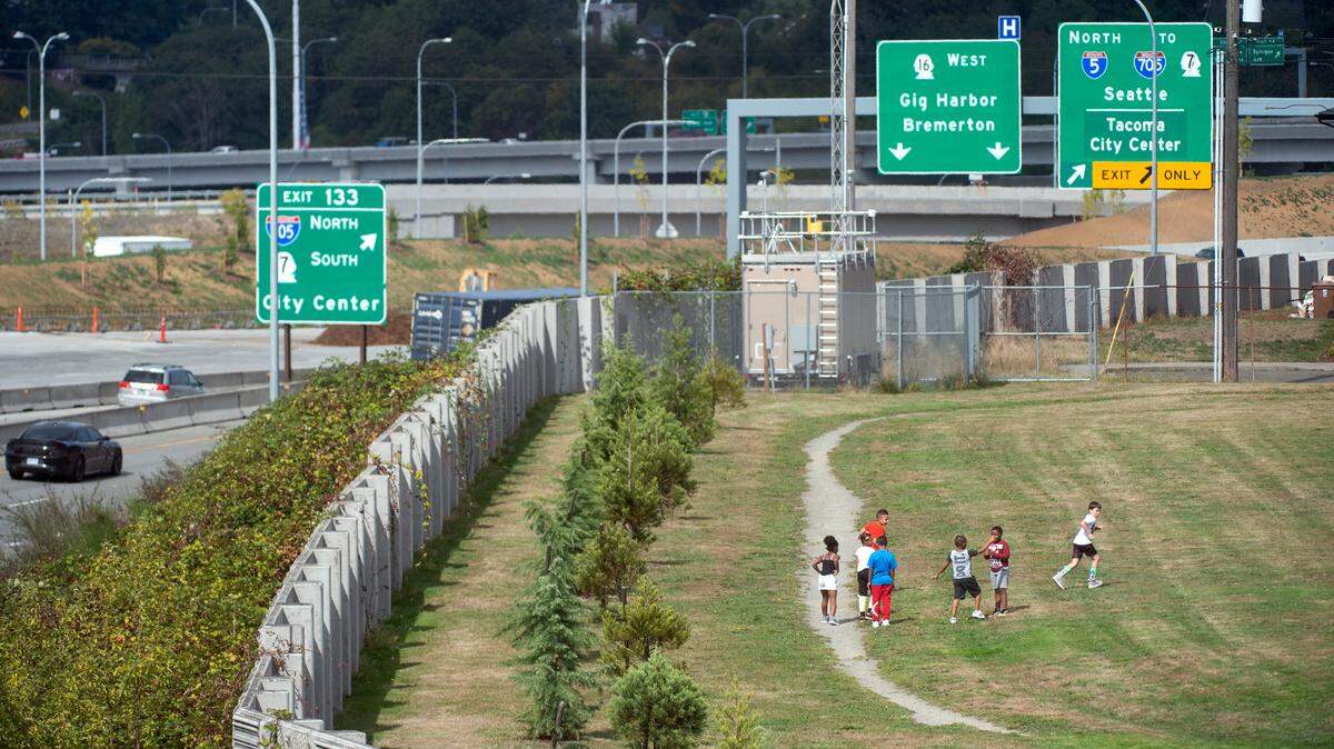 Students gather on the playground at Jennie Reed Elementary School as traffic flies past on Interstate 5 in Tacoma on Wednesday, Sept. 11, 2019. School officials are hoping WSDOT will replace the trees that used to line the freeway to help decrease noise and exhaust.