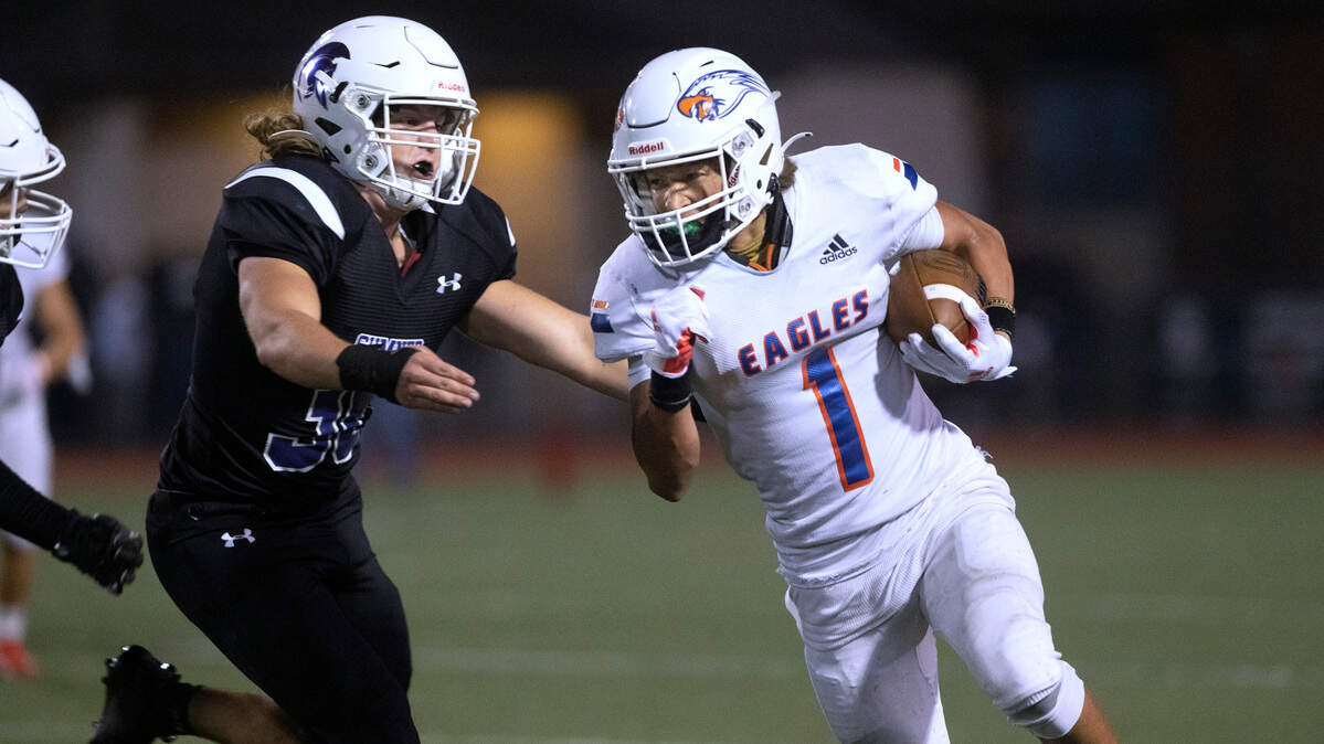 Graham-Kapowsin wide receiver Julian Mason tries to break away from Sumner defensive end Jack Munro during Saturday night’s 4A SPSL high school football game at Sunset Chev Stadium in Sumner, Washington, on Oct. 16, 2021.