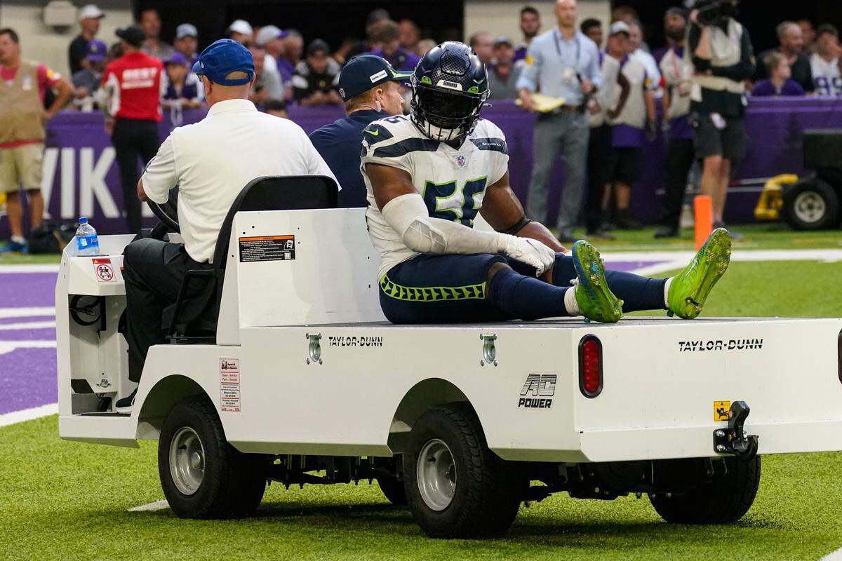 Seattle Seahawks linebacker Jordyn Brooks (56) is taken off the field after being injured in the second half of an NFL football game against the Minnesota Vikings in Minneapolis, Sunday, Sept. 26, 2021. (AP Photo/Jim Mone)