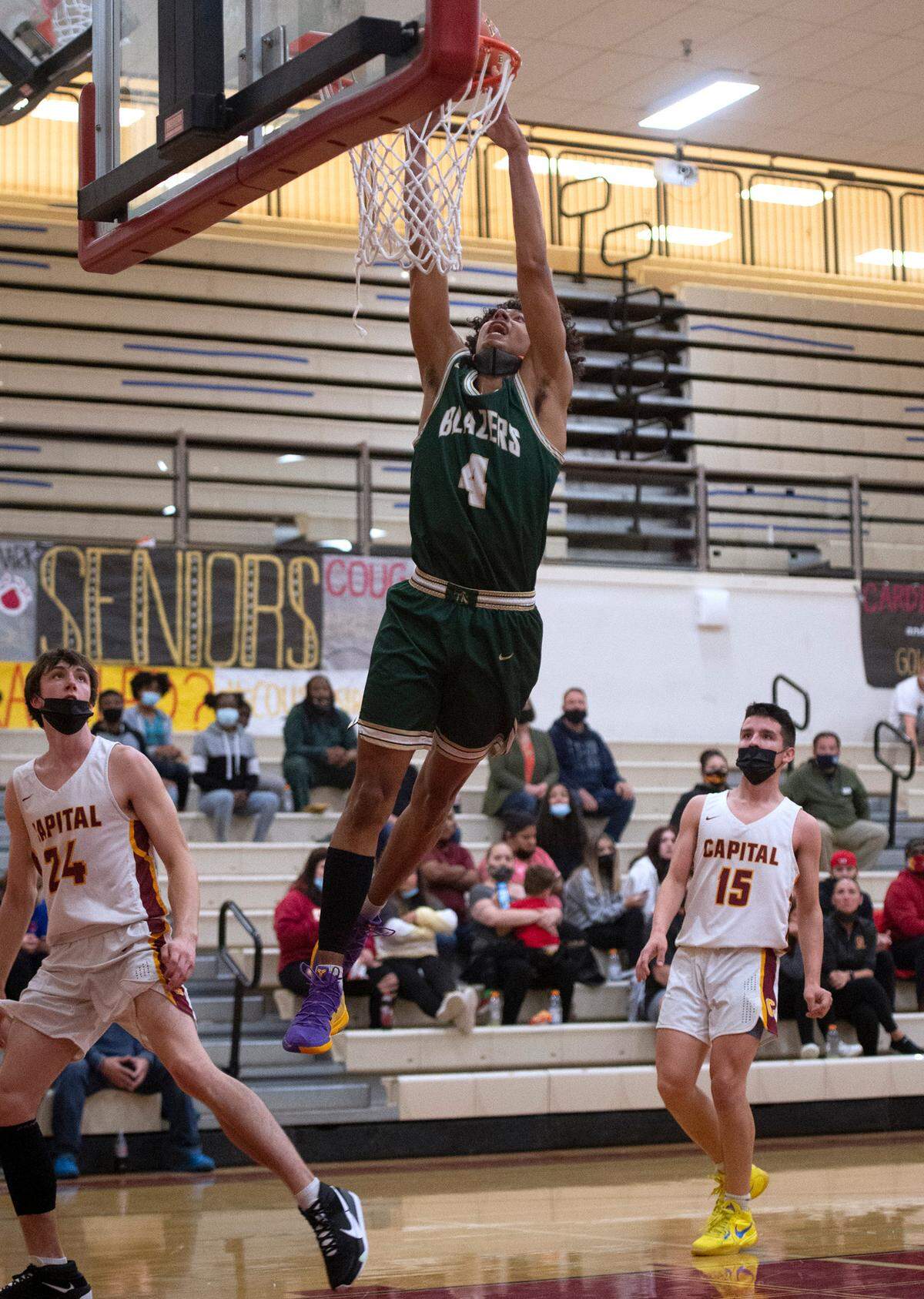 Timberline’s Brooklyn Hicks throws down a dunk in front of Capital defenders Cooper Carlson (24) and Austin Morales during Thursday night’s 3A SSC league boys basketball game at Capital High School in Olympia, Washington, on Friday, June 11, 2021.