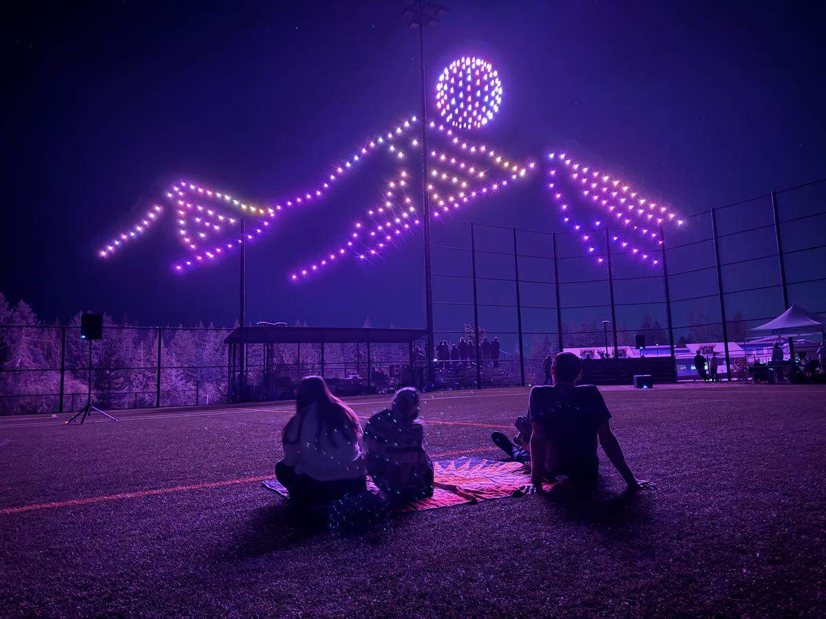 Audience members watch a mountain range appear in the sky as students operate a drone light show at Gig Harbor High School’s upper turf fields Thursday, Sept. 18, 2025, in Gig Harbor, Wash.