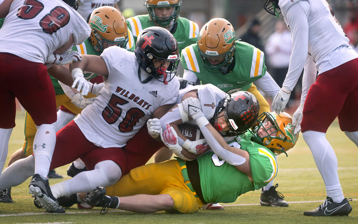 Tumwater linebacker Beckett Wall wraps up Archbishop Murphy running back Jevin Madison during Saturday’s 2A state football semifinal game at Tumwater District Stadium in Tumwater, Washington, on Nov. 30, 2024. Tumwater won the game, 42-0, to advance to next weekend’s state championship game at Husky Stadium in Seattle.
