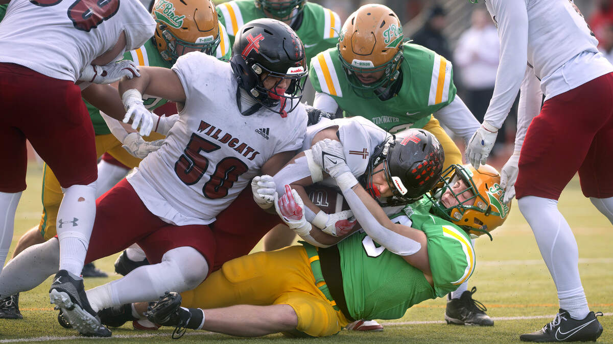 Tumwater linebacker Beckett Wall wraps up Archbishop Murphy running back Jevin Madison during Saturday’s 2A state football semifinal game at Tumwater District Stadium in Tumwater, Washington, on Nov. 30, 2024. Tumwater won the game, 42-0, to advance to next weekend’s state championship game at Husky Stadium in Seattle.