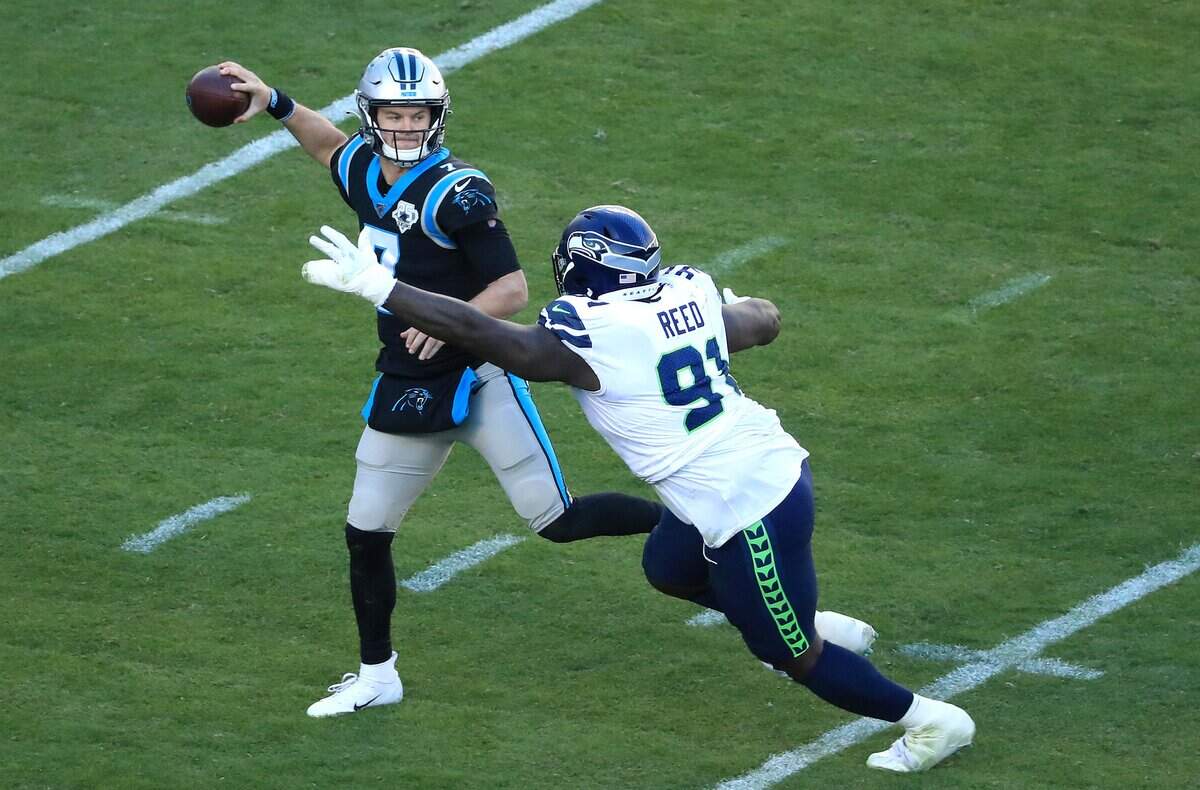 CHARLOTTE, NORTH CAROLINA - DECEMBER 15: Jarran Reed #91 of the Seattle Seahawks tries to stop Kyle Allen #7 of the Carolina Panthers during their game at Bank of America Stadium on December 15, 2019 in Charlotte, North Carolina. (Photo by Streeter Lecka/Getty Images)