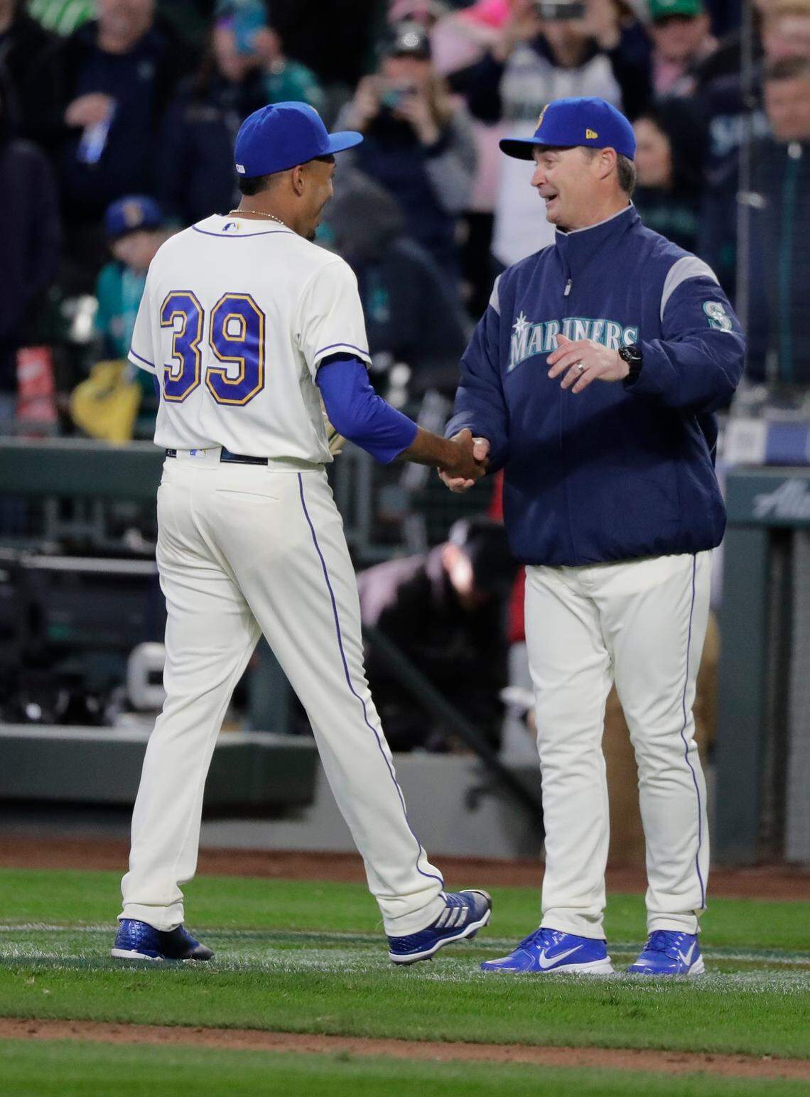 Seattle Mariners manager Scott Servais, right, greets closing pitcher Edwin Diaz after a baseball game against the Cleveland Indians, Sunday, April 1, 2018, in Seattle. (AP Photo/Ted S. Warren)