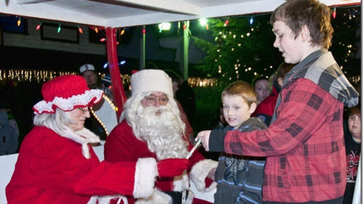 Santa and Mrs. Claus givie candy to Bailey and Carson Leib at a tree lighting at Key Center.