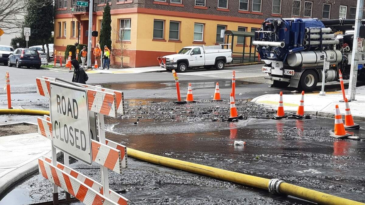 A hose connected to a fire hydrant runs through the intersection at Fawcett Avenue and 9th Street in Tacoma on Tuesday. Several fire trucks were at the scene of a structural fire that was reported early morning.