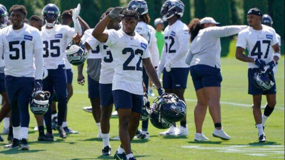 Cornerback Tre Brown (22) gets the rookie treatment carrying veterans’ helmets off the field following practice at Seahawks training camp in Renton.