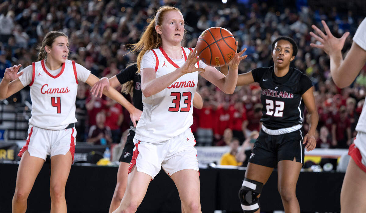 Camas’ Addison Harris dishes off a pass in front of Eastlake defender Kaylia Jackson (22) during the 4A girls state title game at the WIAA state basketball tournament in the Tacoma Dome in Tacoma, Washington, on Saturday, March 4, 2023.