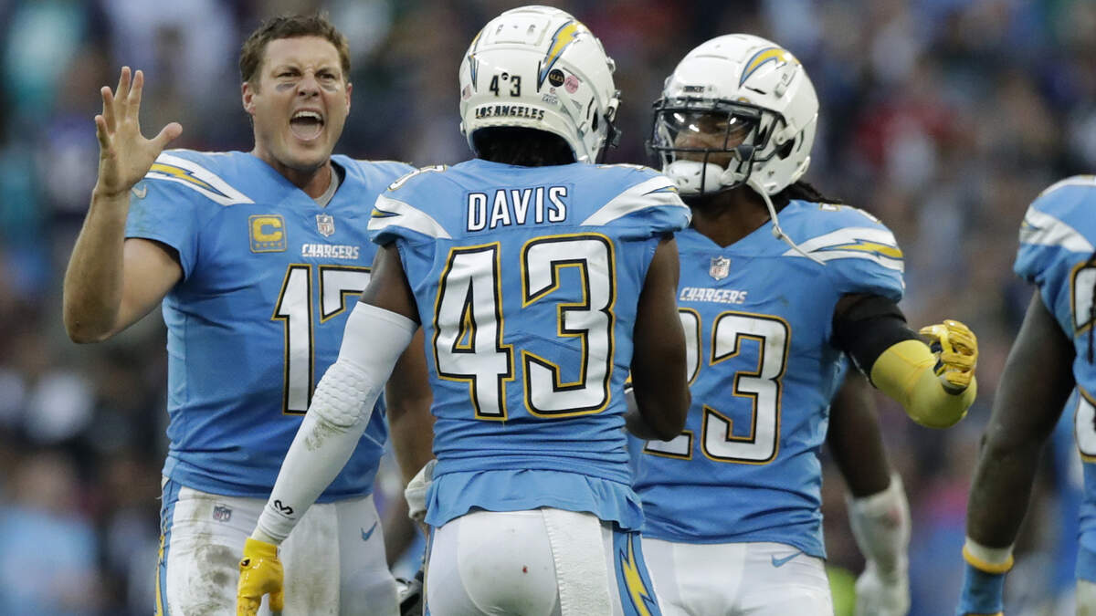 Los Angeles Chargers quarterback Philip Rivers (17), left, celebrates with teammates after a successful defensive play near the end of the second half of an NFL football game against Tennessee Titans at Wembley stadium in London, Sunday, Oct. 21, 2018. Los Angeles Chargers won the match 20-19. (AP Photo/Matt Dunham)