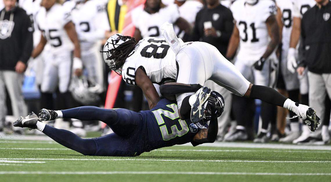 Seattle Seahawks safety D'Anthony Bell (23) gets a hit on Las Vegas Raiders tight end Ian Thomas (80) during the second quarter of the game at Lumen Field, on Thursday, Aug. 7, 2025, in Seattle, Wash.
