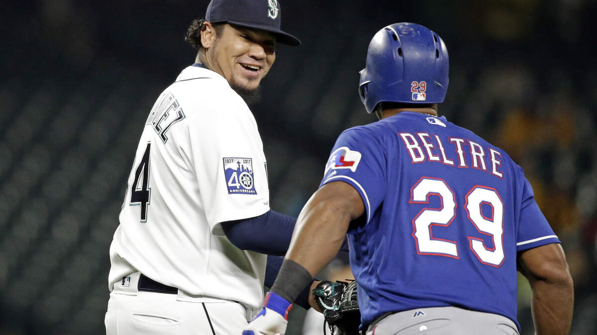 Seattle Mariners starting pitcher Felix Hernandez, left, smiles at Texas Rangers’ Adrian Beltre as Beltre heads off the field after grounding out during the second inning of a baseball game Wednesday, Sept. 20, 2017, in Seattle. Hernandez had commented to Beltre about how quickly he ran to first. (AP Photo/Elaine Thompson)