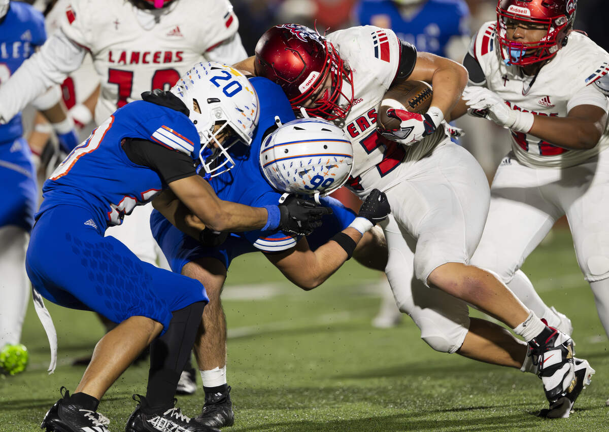 Kennedy Catholic running back Nikko Lecksiwilai (42) hits Graham Kapowsin edge rusher Julius Hernandez-Avila (99) and safety Jhyson Laupati (20) during the first half of the opening round 4A state tournament game at Art Crate Field, on Saturday, Nov. 15, 2025, in Spanaway, Wash.