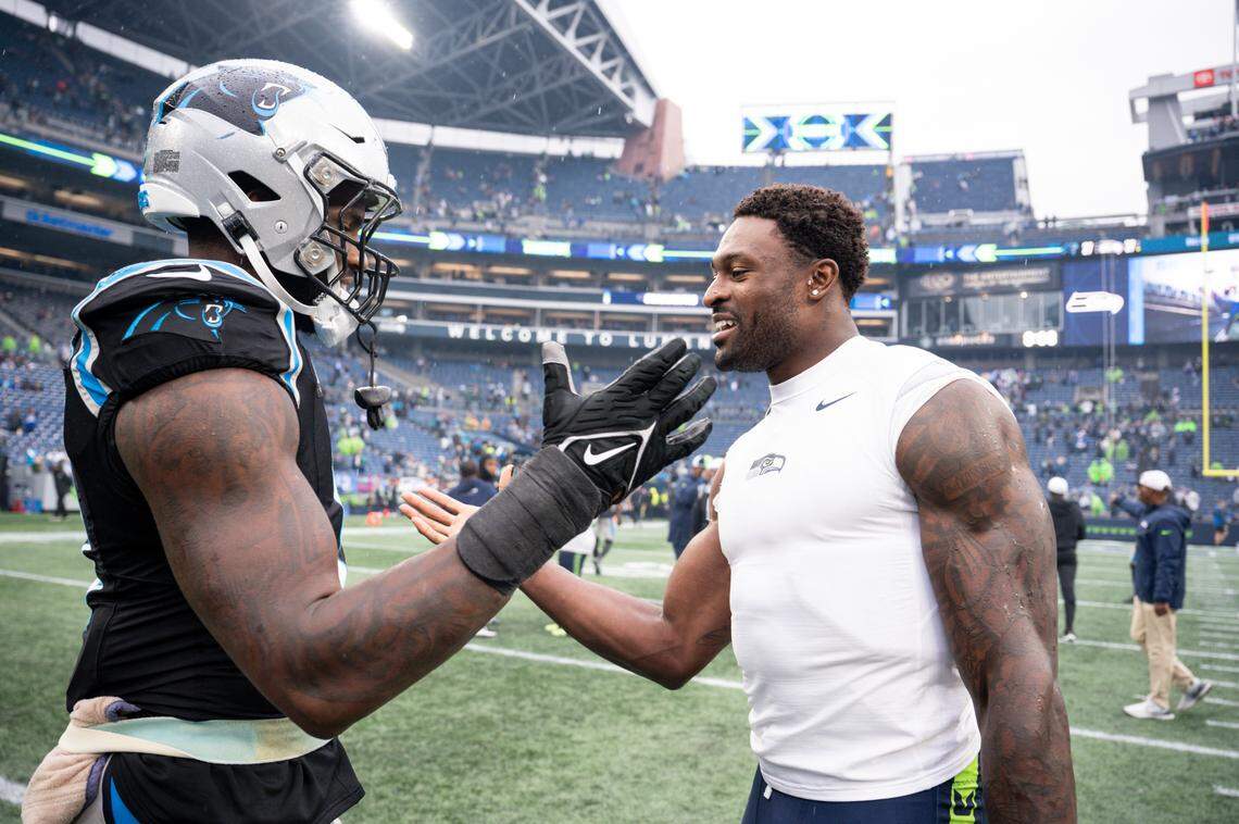 Carolina Panthers linebacker Brian Burns (0) and Seattle Seahawks wide receiver DK Metcalf (14) greet each other after Seattle Seahawks 37–27 victory at Lumen Field, Sunday, Sept. 24, 2023, Seattle, Wash.
