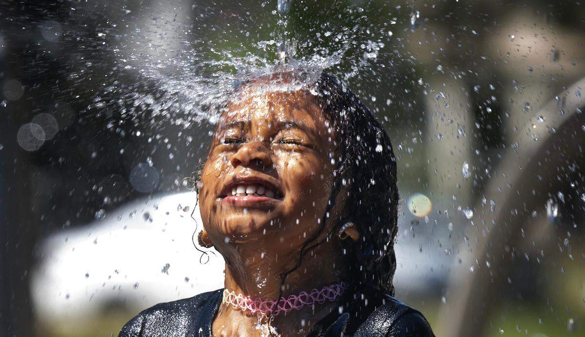 With temperatures pushing 90 degrees before noon, Khamiira Richardson, 5, of Orange County, California, cools off at the Wright Park Sprayground while on summer vacation in Tacoma, Washington, on Monday, July 8, 2024.