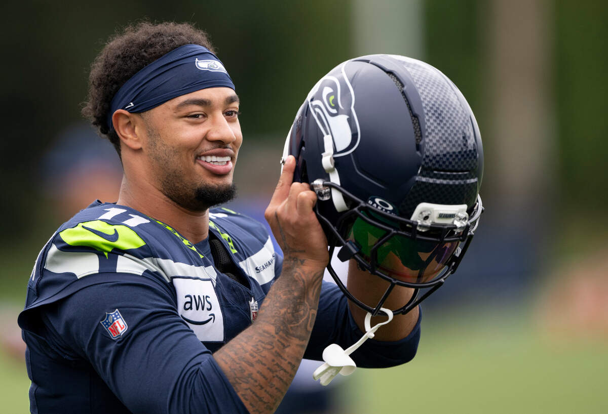 Seattle Seahawks wide receiver Jaxon Smith-Njigba (11) puts on his helmet during training camp at Virginia Mason Athletic Center on Friday, July 25, 2025, in Renton, Wash.