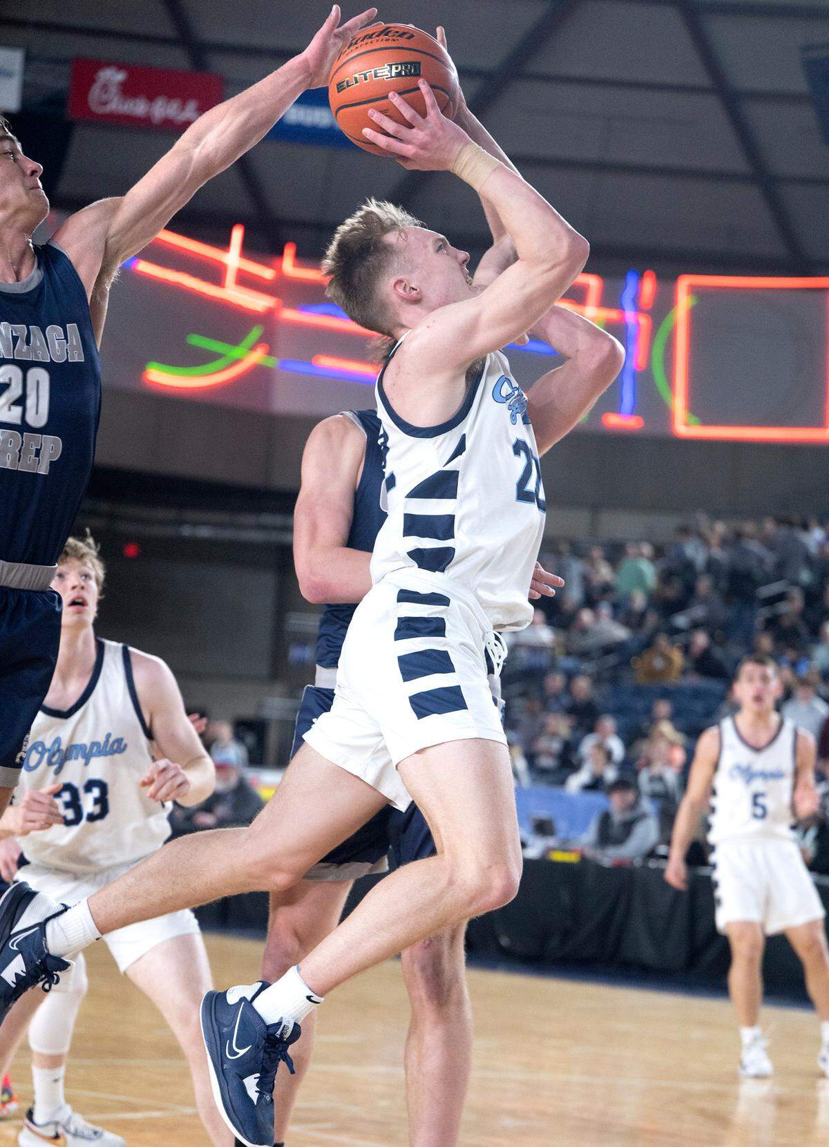 Olympia’s Parker Gerrits powers to the basket under pressure from Gonzaga Prep defender Henry Sandberg during their state quarterfinal game at the WIAA state basketball tournament in the Tacoma Dome in Tacoma, Washington, on Wednesday, March 1, 2023. Olympia won the game, 51-47.