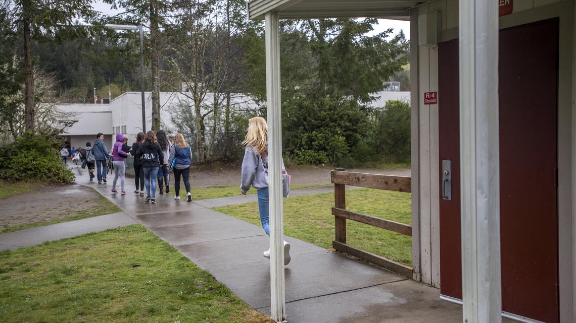 Students head from portable classrooms back to the main building at Key Peninsula Middle School, April 12, 2018.  The district would like to have fewer classes in the portables, partly because having no bathrooms among them and locked doors at the main building wastes students' time.