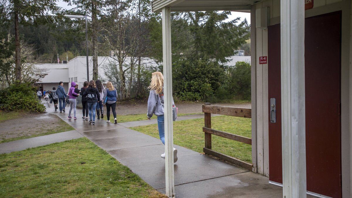 Students head from portable classrooms back to the main building at Key Peninsula Middle School, April 12, 2018.  The district would like to have fewer classes in the portables, partly because having no bathrooms among them and locked doors at the main building wastes students' time.