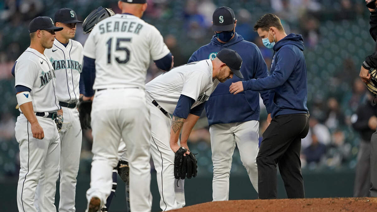 Seattle Mariners starting pitcher James Paxton, third from right, talks with manger Scott Servais, second from right, and a trainer after he experienced an injury, during the second inning of the team’s baseball game against the Chicago White Sox on Tuesday, April 6, 2021, in Seattle. Paxton left the game. (AP Photo/Ted S. Warren)