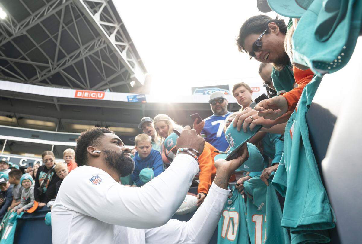 Miami Dolphins running back Raheem Mostert (31) signs autographs for fans before the game against the Seattle Seahawks at Lumen Field, on Sunday, Sept. 22, 2024, in Seattle, Wash.
