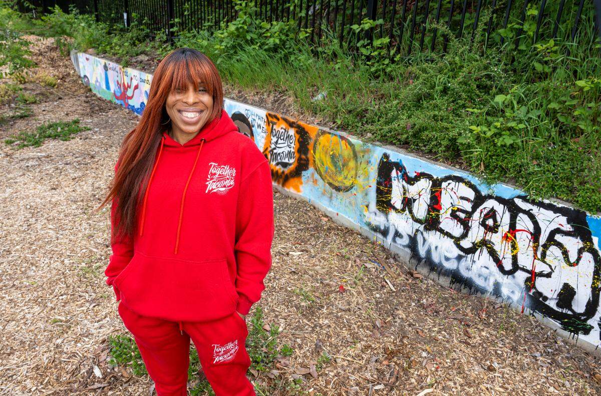 Jamese Williams, founder of Together Tacoma, stands in front of a section of the alleyway along South D Street that her students painted as part of the effort to beautify the area on Wednesday, May 7, 2025, in Tacoma, Wash.
