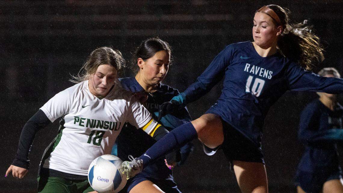Auburn Riverside’s Ava Morton kicks the ball away from Peninsula midfielder Stella Demianiw while in front of goal during the first half of the 3A West Central/Southwest bidistrict championship game on Thursday, Nov. 3, 2022, at Mount Tahoma High School in Tacoma, Wash.