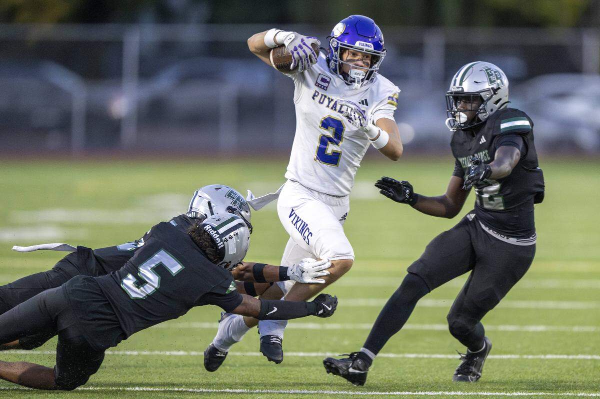 Puyallup's Jayden Woodland (2) dodges Emerald Ridge defenders Jesus Sepulveda (5), front, and Jerin Biembongo (12), right, during the first half of a game on Friday, Sept. 26, 2025, in Puyallup, Wash.