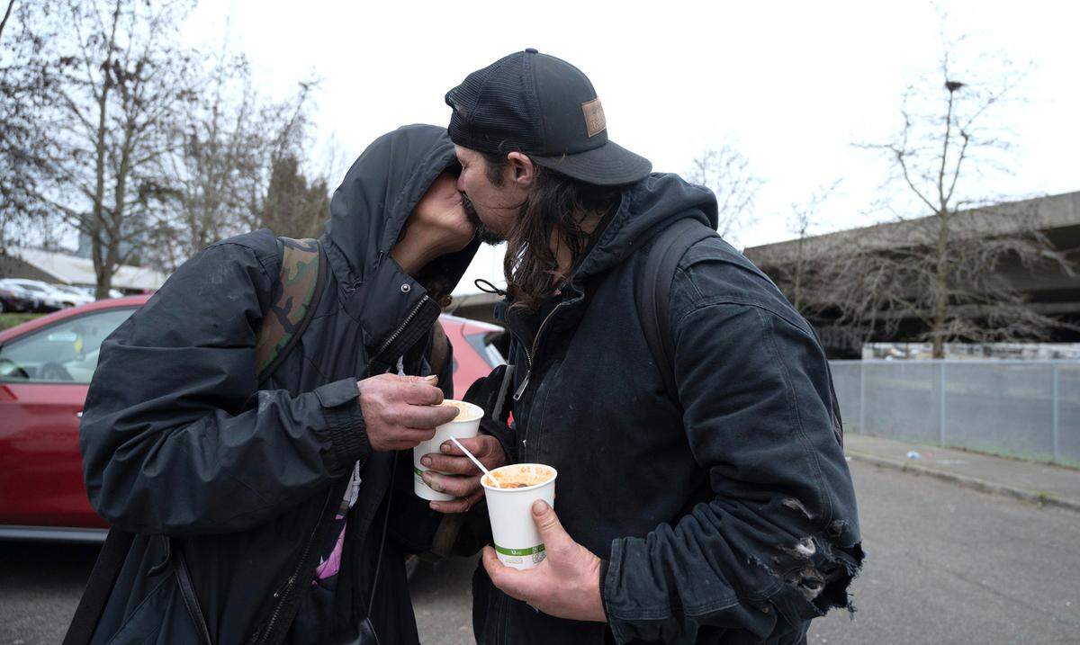 Crystal and Robert share a kiss after receiving cups of hot jamalaya soup from “Mr. Terry” Hayes’ “Da Van that know The Man” food truck in downtown Tacoma, Washington, on Monday, Feb. 5, 2023.