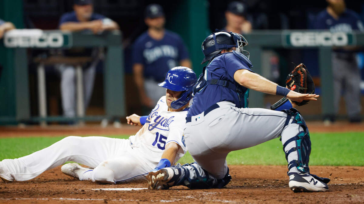 Kansas City Royals’ Whit Merrifield (15) is safe at home plate as Seattle Mariners catcher Tom Murphy, right, gets a late throw during the eighth inning of a baseball game at Kauffman Stadium in Kansas City, Mo., Saturday, Sept. 18, 2021. Merrifield scored from third base off a Andrew Benintendi sacrifice fly ball. (AP Photo/Colin E. Braley)