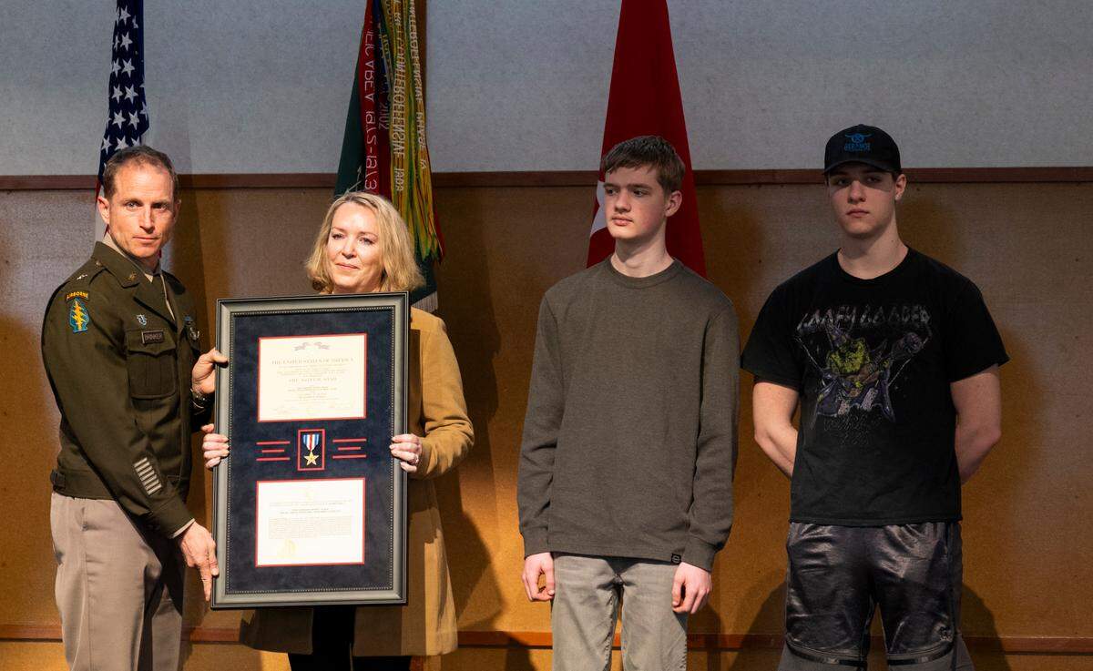 Brigadier General Kirk Brinker hands the Silver Star to Michelle, Isaac and Ezekiel, the widow and children of Special Forces Medical Sergeant Bryan Black during a Silver Star Award Ceremony for at Pioneer Park Pavillion, on Tuesday, April 8, 2025, in Puyallup, Wash.