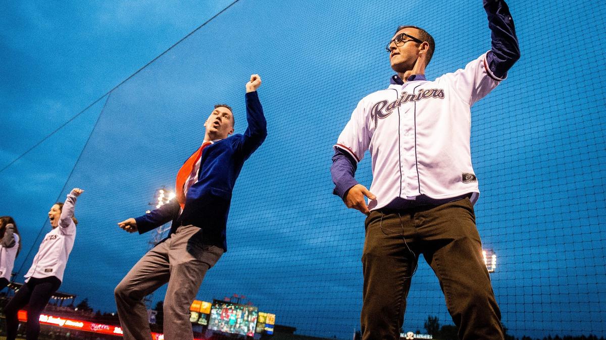 Columnist Matt Driscoll dances on the third base dugout with Casey Catherwood, creative director with the Tacoma Rainiers, and the Rainier Fun Squad, during the seventh inning stretch of the Tacoma Rainiers’ game against the Las Vegas 51s at Cheney Stadium in Tacoma, Wash., on Thursday, June 28, 2018.